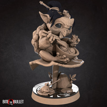 Kappa (anthropomorphic turtle) sitting on a lily pad, eating ramen. Resin miniature by Bite the Bullet.