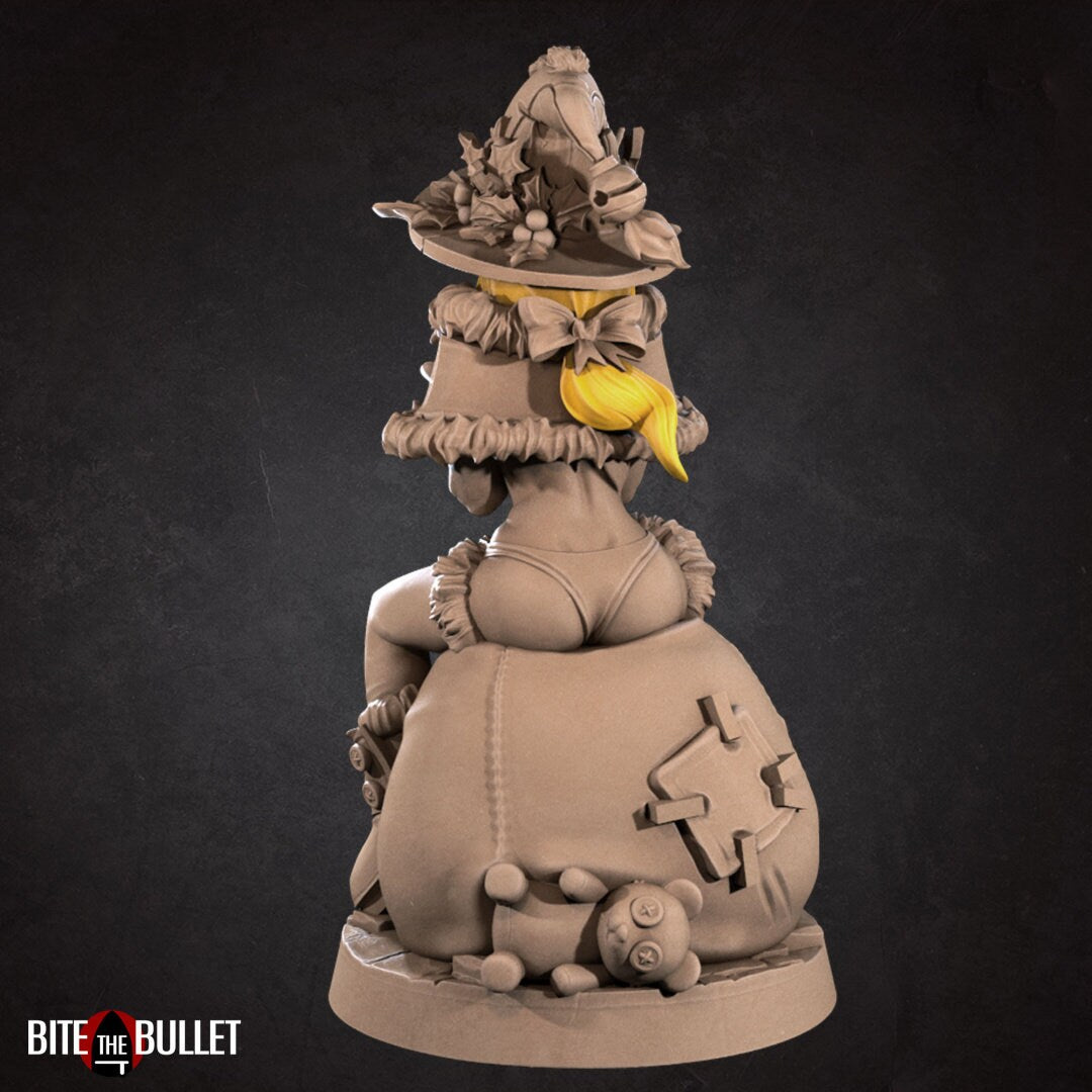 Christmas elf girl with a bare midriff and bikini bottom sitting on a toy snowman head, holding a toy that's sticking its tongue out at her. Resin miniature by Bite the Bullet.