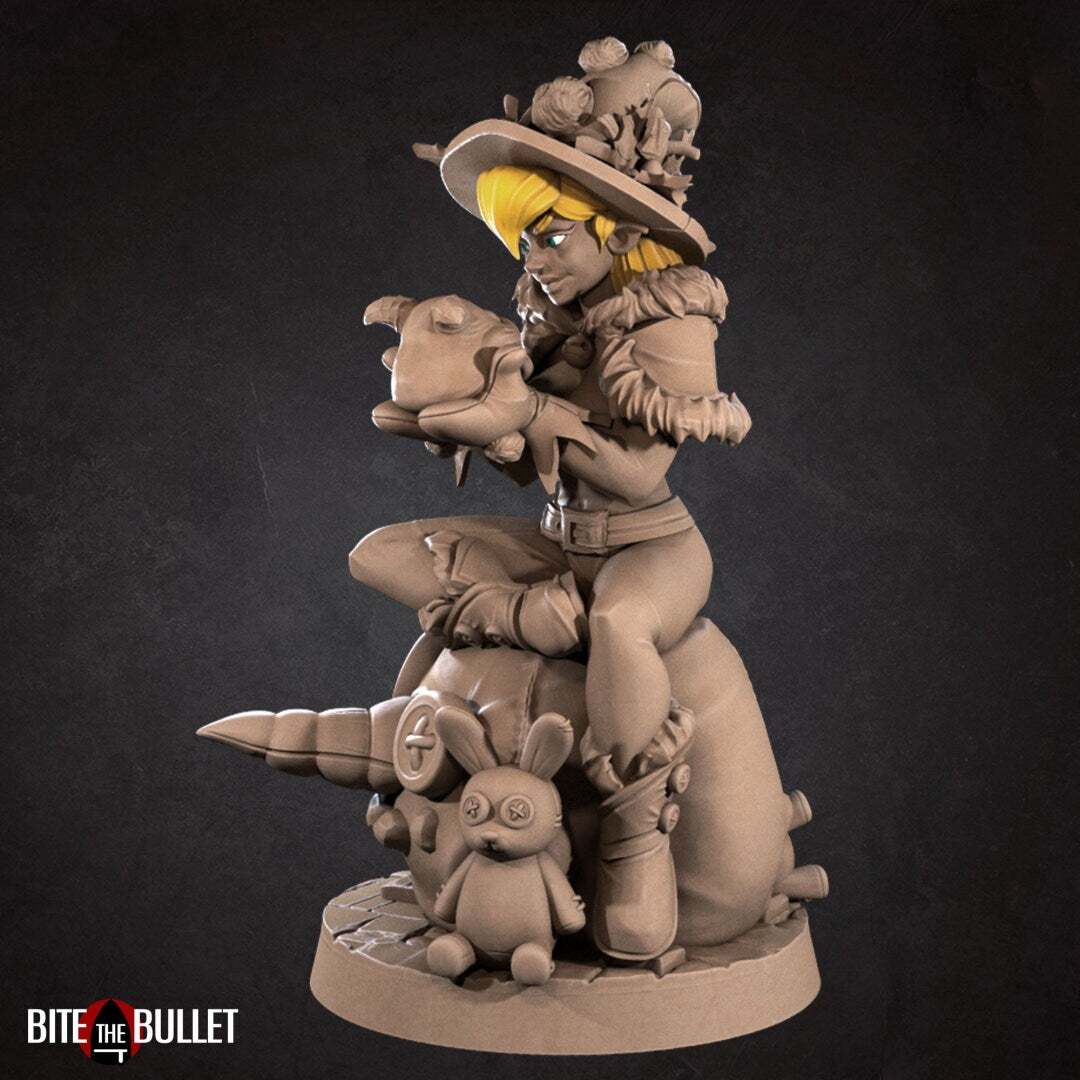 Christmas elf girl sitting on a toy snowman head, holding a toy that's sticking its tongue out at her. Resin miniature by Bite the Bullet.