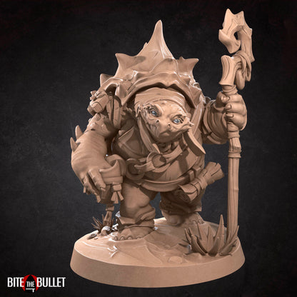 Anthropomorphic turtle with a kindly expression, holding a staff. Resin miniature by Bite the Bullet.
